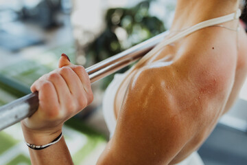 Close-up of a sweaty athletic woman performing a dumbbell workout, focusing on muscle contraction...