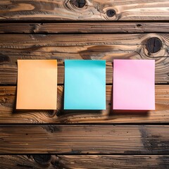 Three blank sticky notes, in pastel colors, affixed to a rustic wooden surface