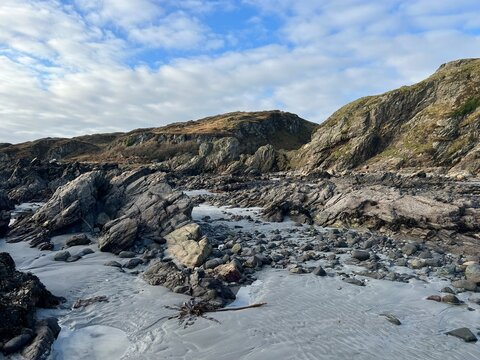 Beautiful wild beach Isle of Mull Scotland Uisken the beautiful rocky and sandy shore sunrise with water pools reflect sun light  vast ocean on horizon with wildlife  and blue sky in Winter no people