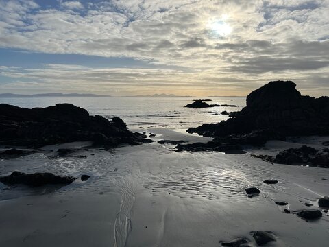 Beautiful wild beach Isle of Mull Scotland Uisken the beautiful rocky and sandy shore sunrise with water pools reflect sun light  vast ocean on horizon with wildlife  and blue sky in Winter no people