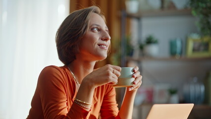 Dreamy woman holding cup hot beverage thinking on creative ideas at home closeup