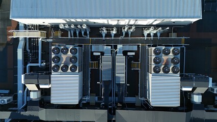 Aerial drone top down rotating view of cooling and ventilation systems on a data storage center warehouse building showing modern infrastructure.