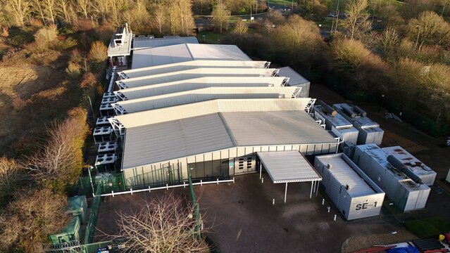 Aerial drone view of large scale cutting-edge technology and futuristic infrastructure of a large-scale data center in Milton Keynes, UK. AI cloud quantum computing.  - Powered by Adobe