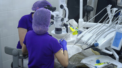 Dentists working under a microscope in a modern clinic