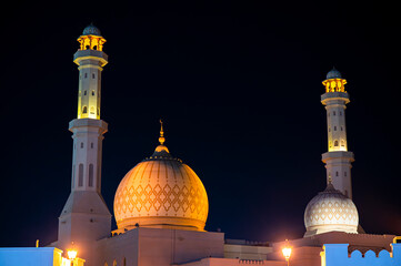 Sur, Oman - November 22,2025: Close-up Night View of the Distinctive Illuminated Dome and Minaret of Bahwan Mosque in Sur, Oman