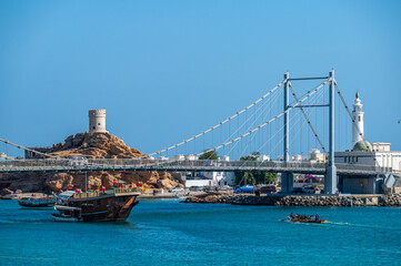 Sur, Oman - November 22, 2025: Suspension Bridge, Historical Watchtower, and Mosque Minaret, Sur, Oman