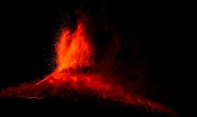 A volcano is erupting in the night sky. The fire is orange and bright, illuminating the dark sky © IgnazioMaurizio