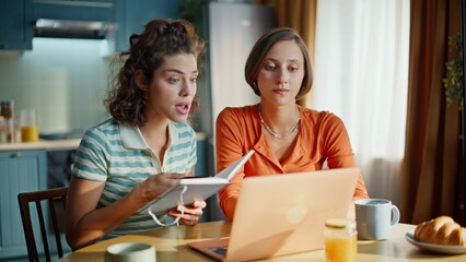 Nervous ladies video calling holding copybook at home closeup. Frustrated women