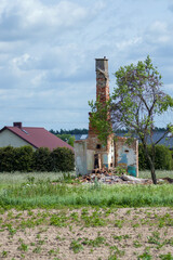 Ruiny starego domu z czerwonej cegły wysokim kominem.