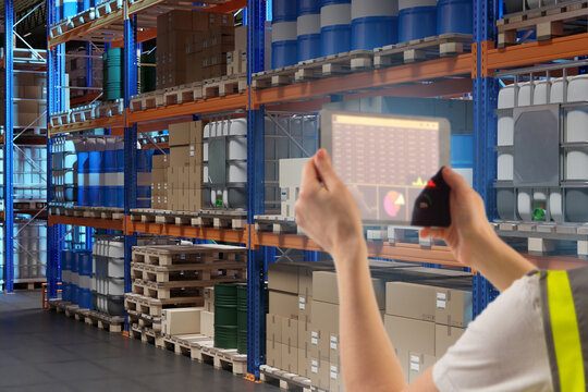 Warehouse inventory analytics performed by a logistics worker using a digital tablet to review stock data. Smart warehousing, supply chain optimization, inventory control, and data-driven operations - Powered by Adobe