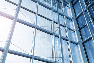 Modern glass building interior. Steel framework and large windows. Contemporary architecture design. Abstract geometric lines background. Corporate office construction detail. Urban business space.