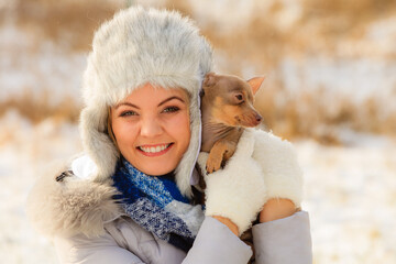 Woman playing with dog during winter