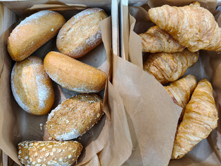 Top view of Basket filled with of sourdough bread and croissant
