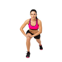 An athletic woman exercising in a studio setting doing lunges and focusing on her fitness. She is healthy and demonstrates how to do exercises to stay in shape