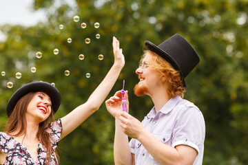 Couple blowing soap bubbles, having fun