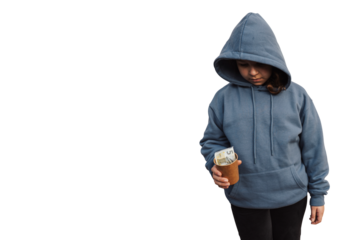 Sad homeless child in blue hoodie holding a paper cup with euro banknote and coins. Concept of poverty and financial crisis isolated on transparent background
