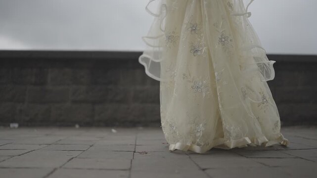 Side view of an Indian bride walking, focus on lower body and dress