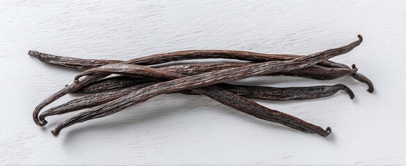 The vanilla beans arranged on a white wooden background for culinary photography