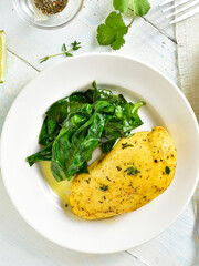 Delicious baked turmeric chicken breast served with sauteed spinach