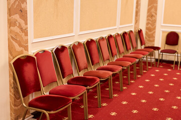 Elegant Ballroom With Red Seating, Charming Hall Featuring Plush Carpets And Golden Accents