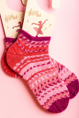 Vibrant pink and red knitted wool socks feature intricate patterns and textures, ideal for cozy winter wear, adding warmth and style to any outfit
