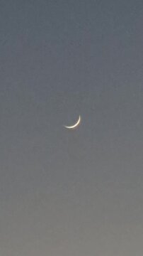 Crescent moon sky twilight new phase of the moon glowing against a serene evening horizon vertical video