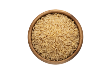 Overhead shot of uncooked brown rice grains in a rustic wooden bowl on a clean white background.