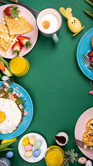 Colorful breakfast spread with pancakes, eggs, fruits, and festive decorations on a green table