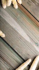 Fresh white asparagus arranged on rustic wooden table with natural textures and colors