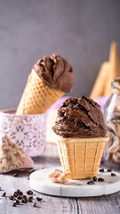 Delicious chocolate ice cream cones on a rustic wooden table with coffee beans and decorative elements