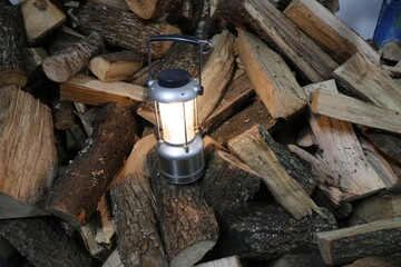 Lantern on a pile of firewood, closeup of photo