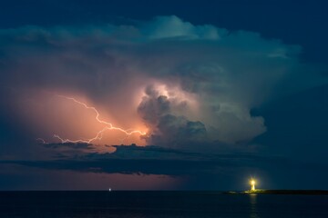Dramatic Lightning Storm Over Coastal Lighthouse at Night