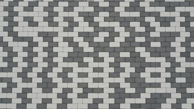 Geometric pattern of grey and white interlocking paving stones creating a visual texture