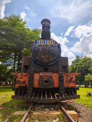 Vintage steam locomotive displayed in a green public park © adityapradanap