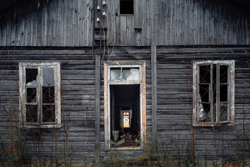 Abandoned house in the woods in autumn cloudy day.