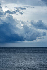 Dramatic Cloudy Sky or Dark storm clouds forming Over Tropical Beach Ocean View and waves. Ideal for moody nature backgrounds, weather concepts, or dramatic seascape themes.