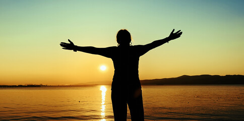 Silhouette Woman Celebrating Sunset At The Beach at Sunset