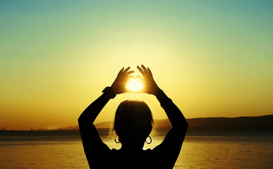 Hands Raised Toward Sun At Golden Hour at Sunset