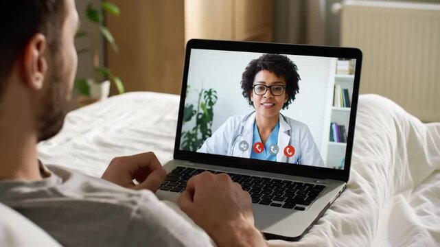Telehealth Consultation Patient In Bed with Doctor on Laptop