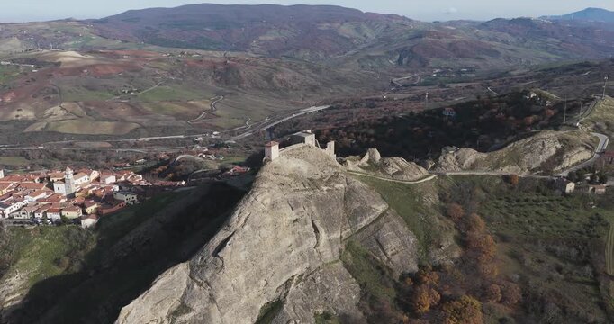 Aerial view of the medieval Brindisi Montagna, with its ancient castle perched atop a rocky hill overlooking the town, Brindisi Montagna, Basilicata, Italy.