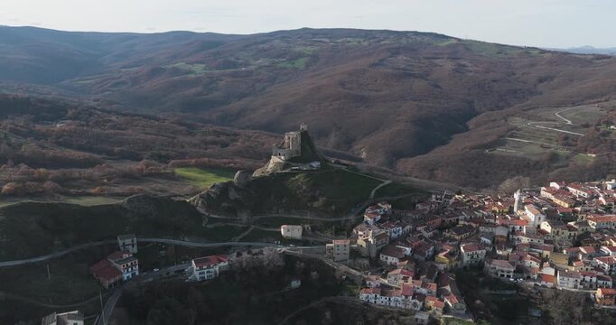 Aerial view of the medieval Brindisi Montagna castle perched atop a hill overlooking the town and surrounding hills, Brindisi Montagna, Basilicata, Italy.