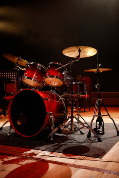 Front view of red acoustic drum set on stage