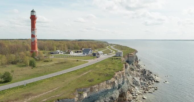 Aerial view of Pakri lighthouse and Pakri old lighthouse on the edge of a high limestone cliff, located on the Pakri peninsula, in sunny spring weather with clouds in the sky, Estonia.