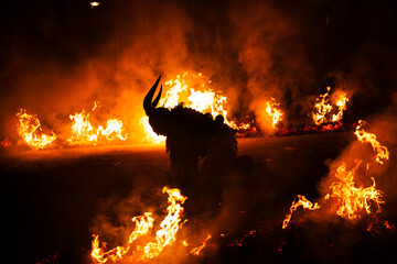 Krampus in the midst of flames is a demonic being that accompanies the religious folkloric figure. This tradition is linked to Christian mythology.