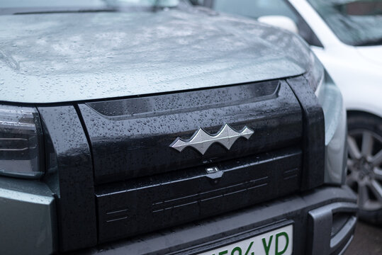 KYIV, Ukraine, December 21, 2025. Close-up of Fangchengbao Tai 3 front grille with  logo emblem, wet surface with raindrops, modern Chinese SUV detail.