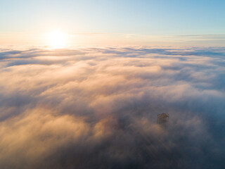 Golden sunset over Velka Homola, lookout tower rising from a sea of clouds. Little Carpathians,...