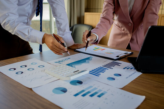 A professional female accountant sits at a desk, carefully examining legal paperwork and auditing financial records to finalize an important deal.