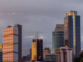 Skyscrapers in Pancoran, Jakarta City, Indonesia, Asia, during sunset or sunrise. Indonesia's capital city landscape. Orange sunlight lit up buildings.