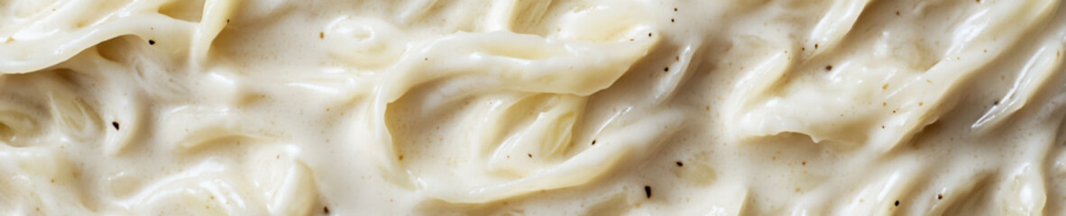 Creamy alfredo pasta sauce texture close up background

