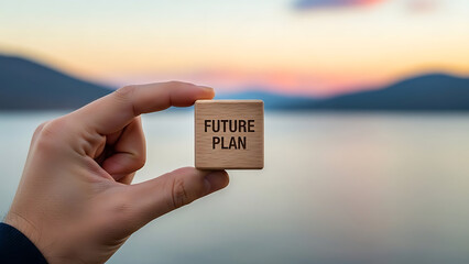 Hand holding a wooden block with future plan text outdoors at sunset